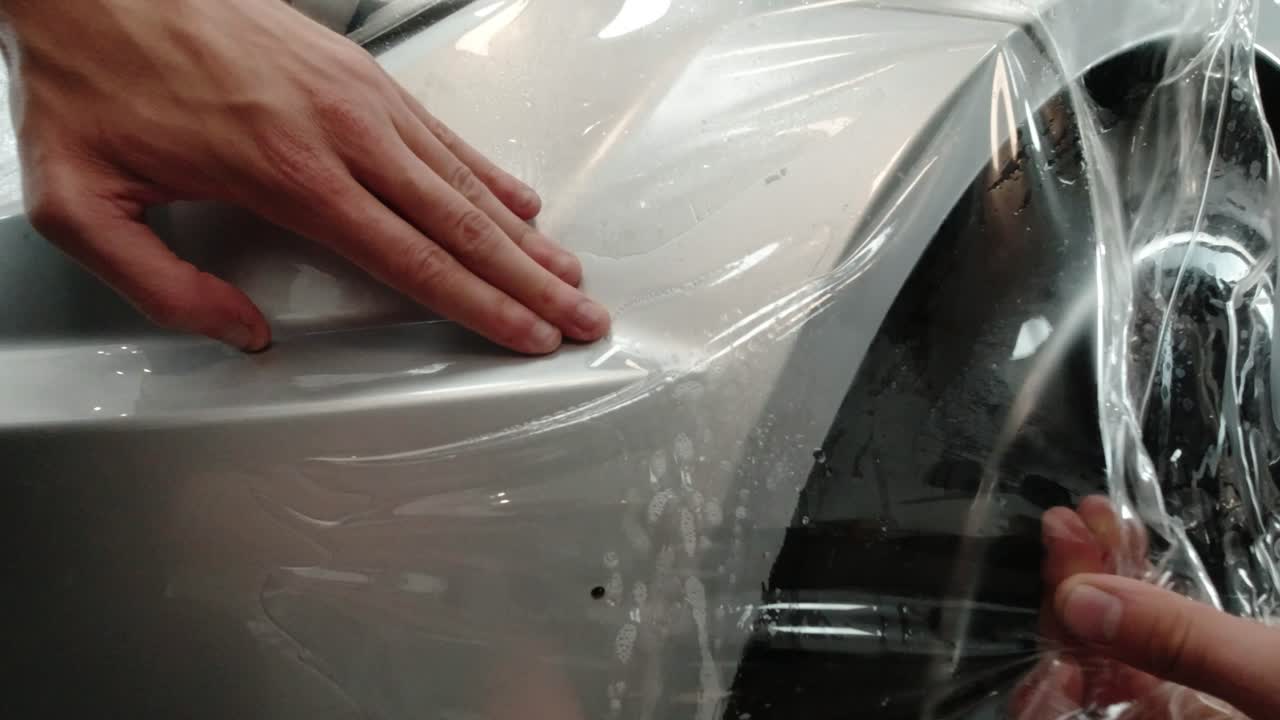 Close up to PPF installation process on silver sports car
