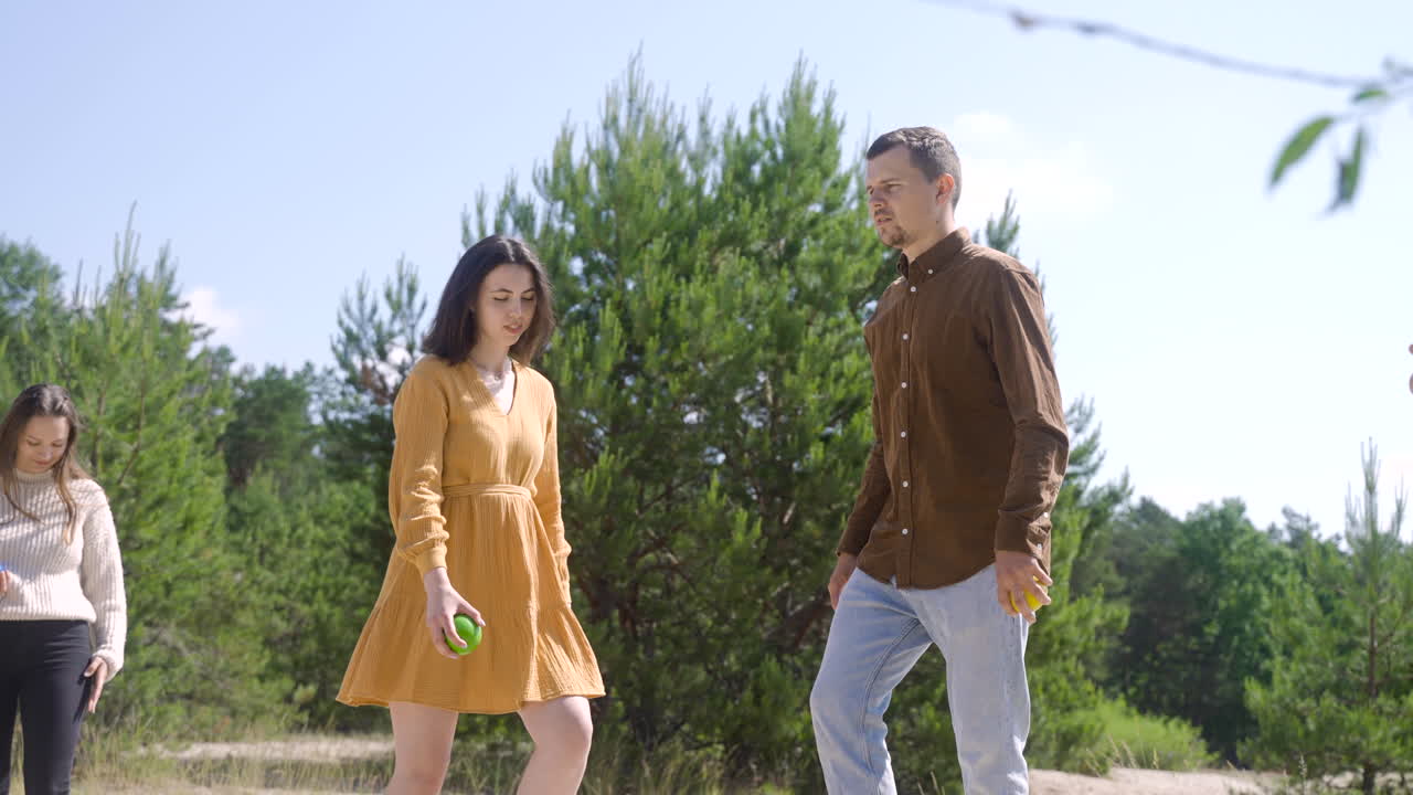 화창한 날 해변에서 페탕크를 연주하는 남녀 친구들