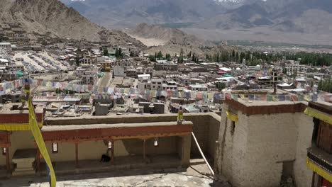 La-Ciudad-De-Leh-Con-Una-Casa-Hecha-De-Barro-Y-Materiales-Locales-Llena-De-Gente-La-Bandera-Budista-Ondeando-Debido-A-Los-Vientos-Vista-Desde-El-Palacio-De-Leh