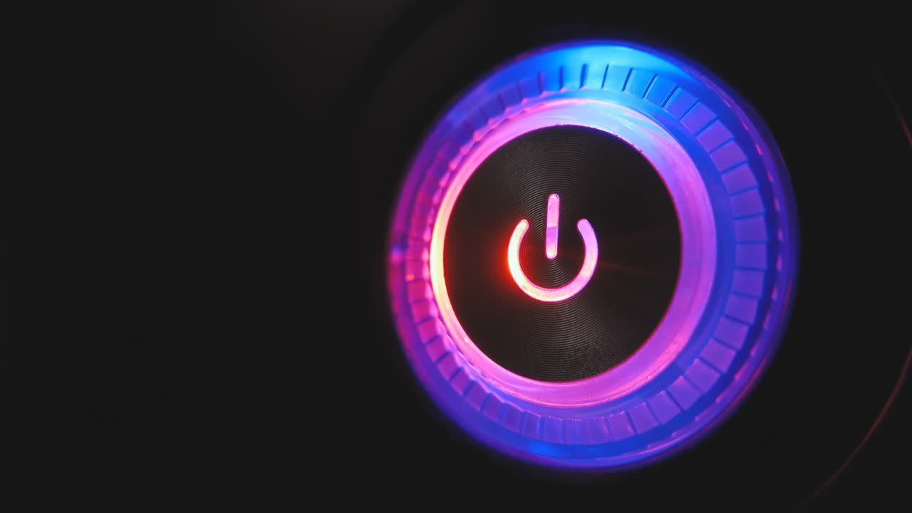 un bucle de video macro de 4k de un botón de encendido de la computadora en la unidad del sistema sobre un fondo negro.