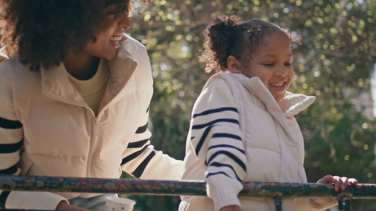 니 파크에서 웃는 어머니와 딸. 가족이 함께 휴식을 취하고 있습니다.