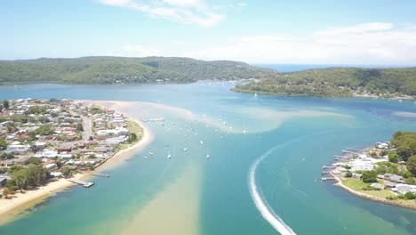 aerial drone video footage of white sands blue water beach over a speed boat in sydney australia