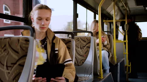 joven usando una tableta en el autobús