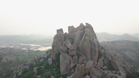 orbiting aerial of natural rock boulder formation in foggy hampi india