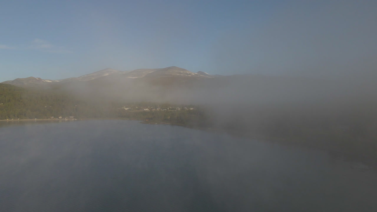 Aerial shot flying through cloud and mist in the mountain ranges of Norway