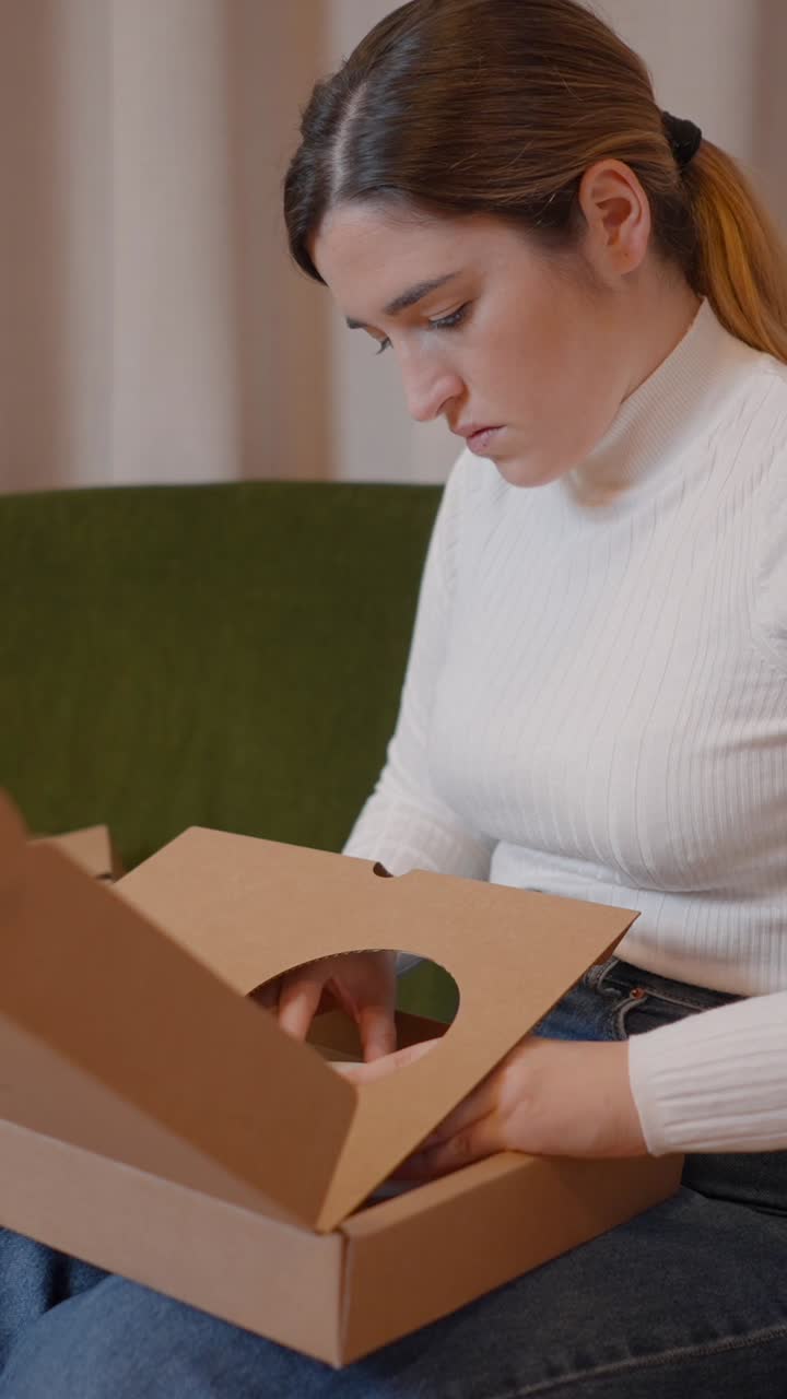 A woman unboxing a package at home