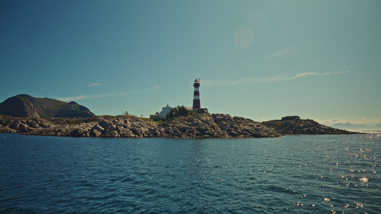 Boat tour around the small fishing islands of the Lofoten, Norway. View of a small lighthouse from the sea.