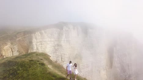 couple hiking in foggy cliffs of france