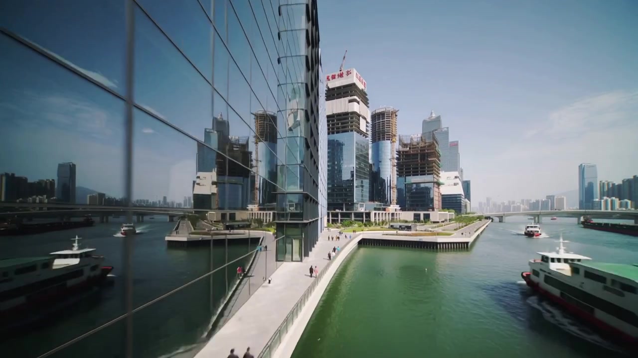 Sweeping camera starting by lattice facade at waterfront quay, revealing ferries and river traffic
