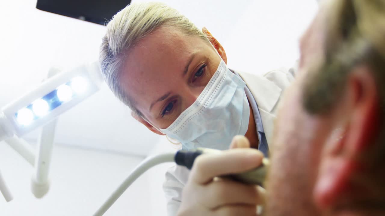 Dentista che esamina un paziente con gli strumenti