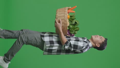 man carrying a basket of vegetables on a green screen