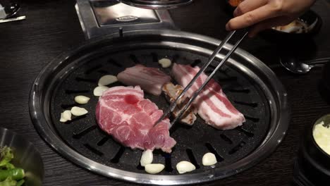 숯불 그릴에 마늘을 곁들인 삼겹살 굽기 - 한국 요리