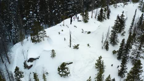 Toma-Panorámica-Hacia-Atrás-Aérea-De-Un-Grupo-De-Personas-En-Una-Montaña-Nevada