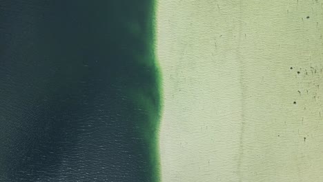 aerial view of barrier between fresh and salt water on the lofoten islands in norway with a sweeping movement upwards revealing the surrounding landscape of mountains and fjords