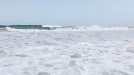 olas llegando a una playa creando espuma de mar