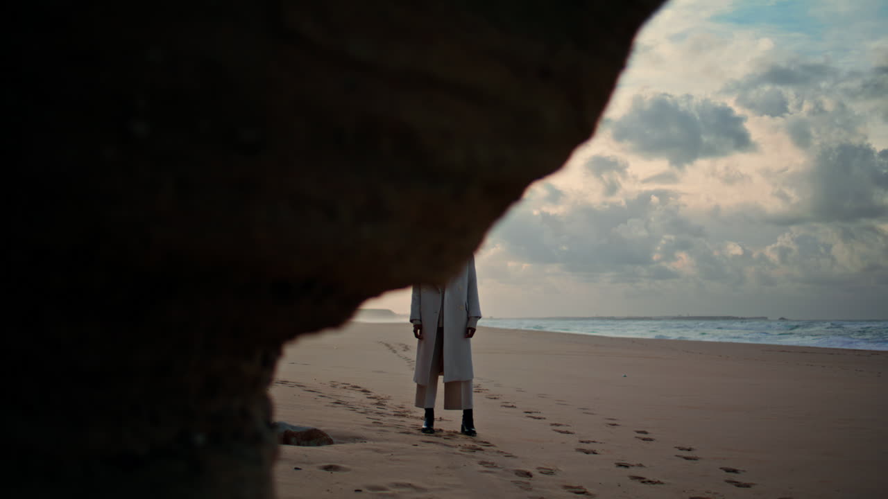 mujer serena admirando la playa del océano en un día nublado. fin de semana pacífico en la orilla del mar