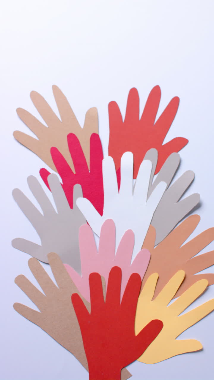 Vertical video of hands made of colourful paper on white background with copy space