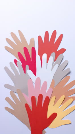 vertical video of hands made of colourful paper on white background with copy space