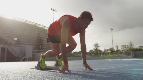 Vista-Lateral-Del-Atleta-Caucásico-Preparándose-Para-La-Carrera-En-El-Estadio.