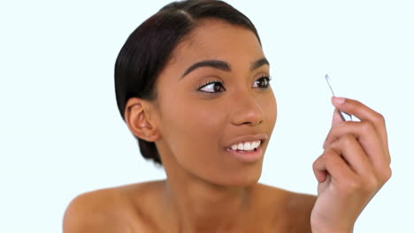 mujer arrancando cejas con pinzas