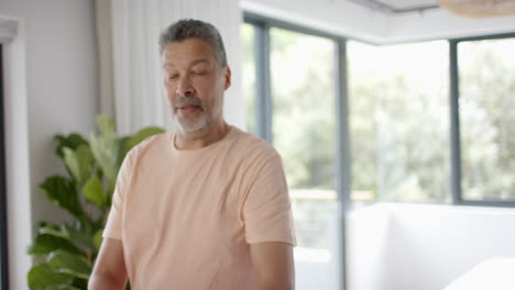 Senior-biracial-man-exercising,-practicing-yoga-at-home