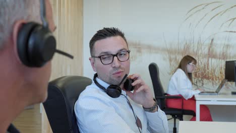 people working and communicating with headphones in an office
