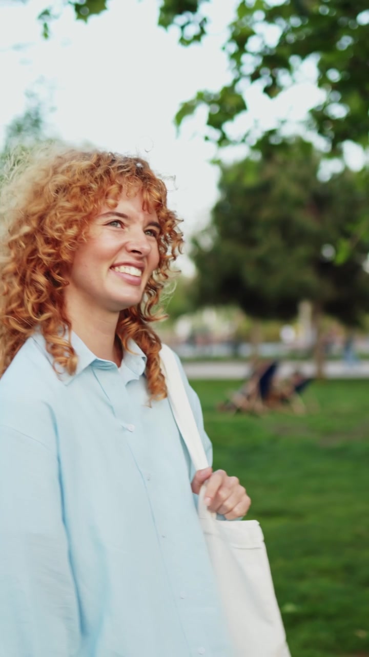 Kıvırcık Kızıl Saçlı Mutlu Genç Kadın Parkta Gülümsüyor