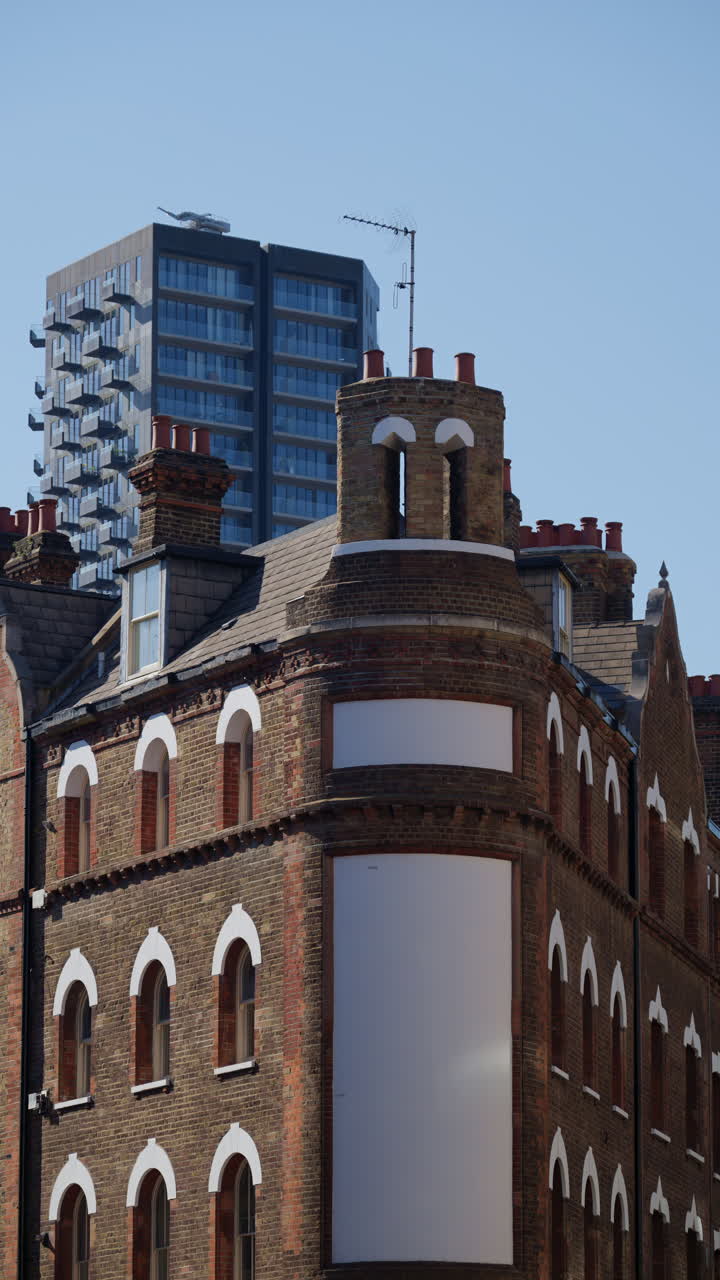 Buildings in central London, England with contrasting red and brown facades in daylight. Vertical