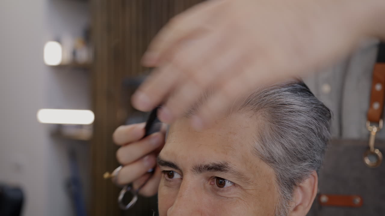 한 남자가 이발장에서 헤어스타일을 하고 있다.