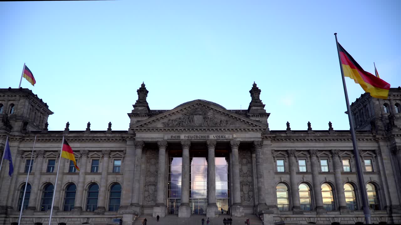 Reichstag, Berlin, Sunset reflecting in windows, people casually passing by