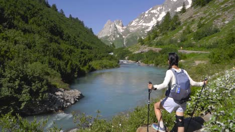 a female hiker walks near crystal-clear alpine lakes in the mont blanc region, capturing the serene landscape