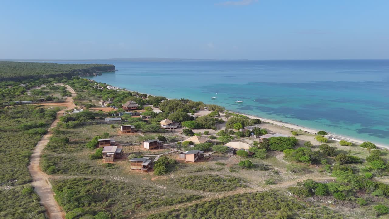 Dominik Cumhuriyeti'nin Pedernales şehrindeki Playa La Cueva'da, parlak güneş altında Eco del Mar tatil köyünün havadan panoramik görünümü