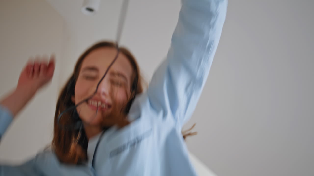 Closeup morning woman listening music at home. Smiling female jumping at bed