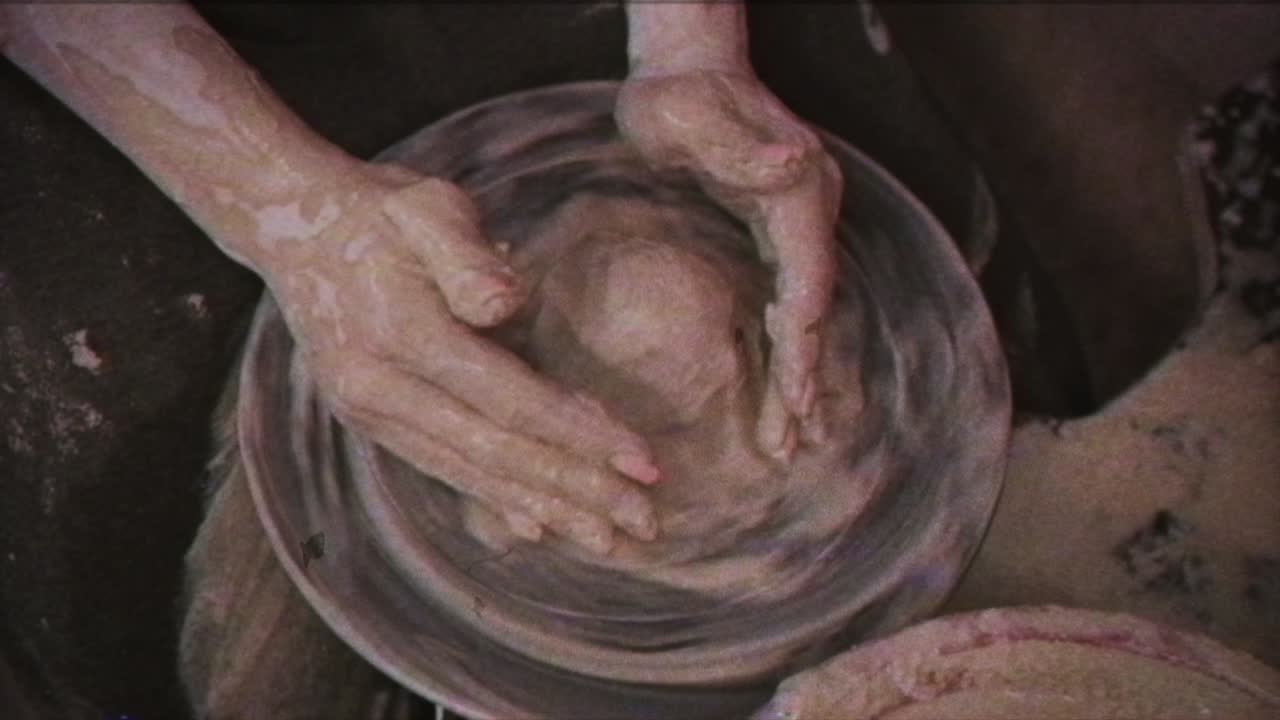 un alfarero enseña a una mujer a hacer platos de arcilla. un hombre toma las manos de una mujer. efecto vintage.