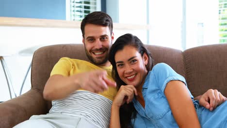 Portrait-of-smiling-couple-relaxing-on-sofa-in-living-room