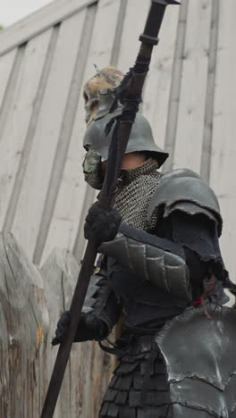 dark knight sneaks into settlement to fight village residents. evil warrior prepares to attack local people. medieval battles closeup on blurred background