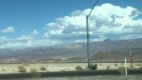 beautiful big white clouds in the sky while driving down hot desert highway in arizona tracking shot stabilized handheld