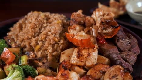 surf and turf hibachi plate, mixed proteins lobster steak scallops shrimp fried rice mixed vegetables, slider close up 4k