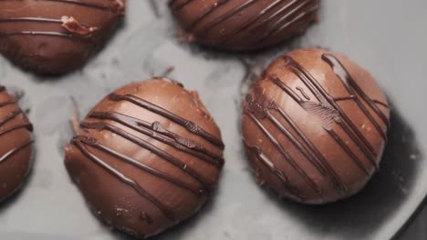round shape dark chocolate on a plate on pink background