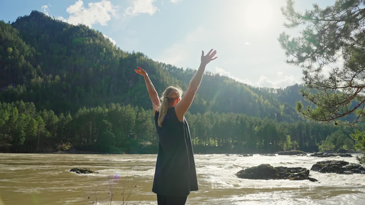 Woman enjoying the view of a scenic river and mountains