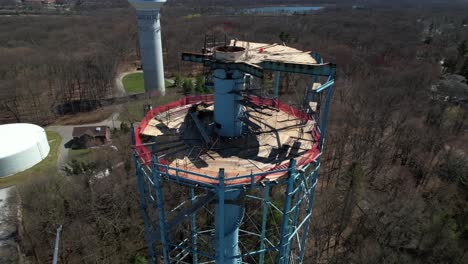 an aerial view of a water tower in the process of being dismantled on a sunny day on long island, new york