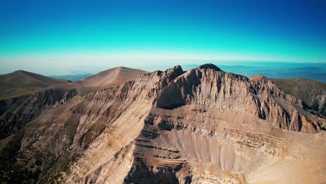 establishing wide drone shot of mountain olympus on a sunny summer day with blue sky and no clouds, summit