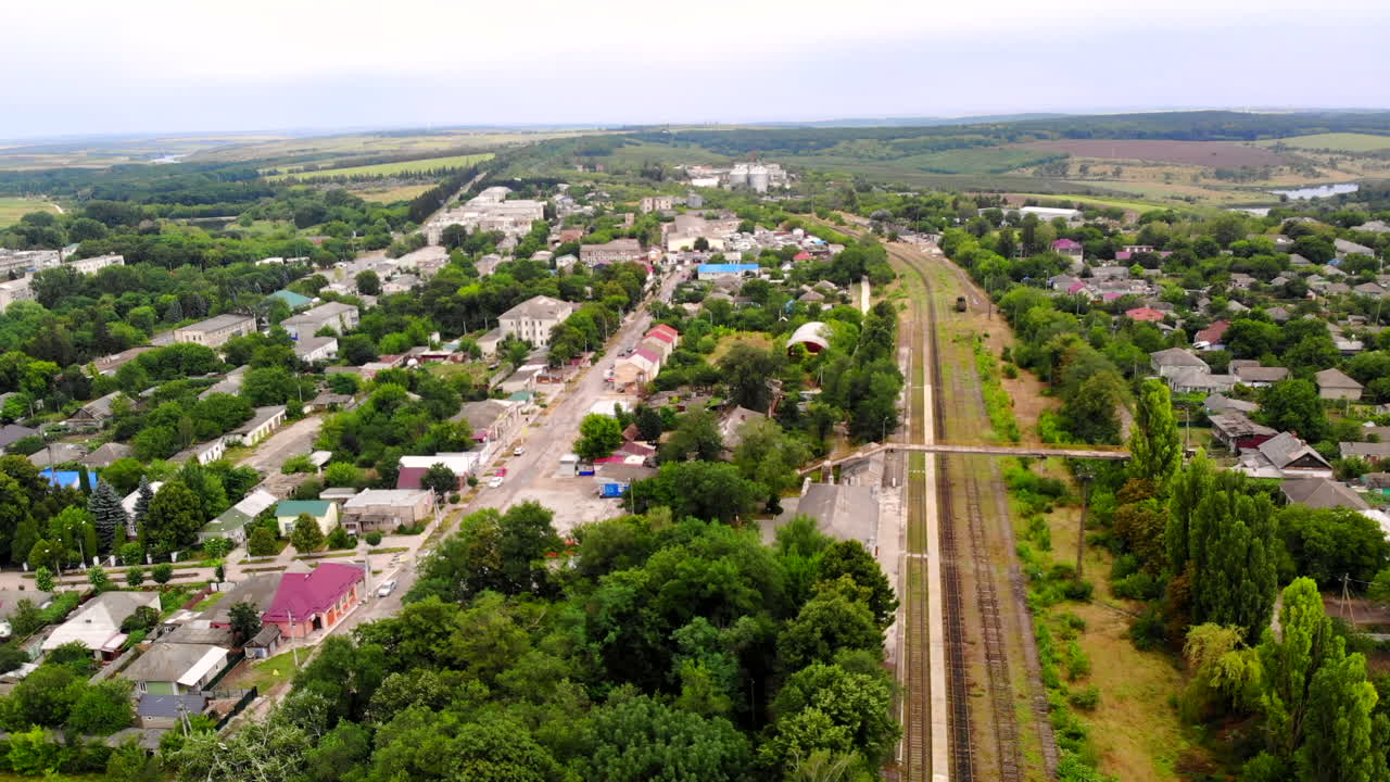 Aerial drone shot of Donduseni city with multiple residential buildings and greenery and fields in Moldova