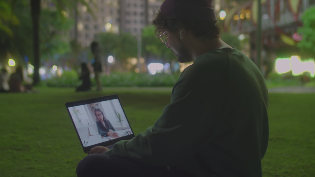 Man Video Calling on Laptop in Park at Night