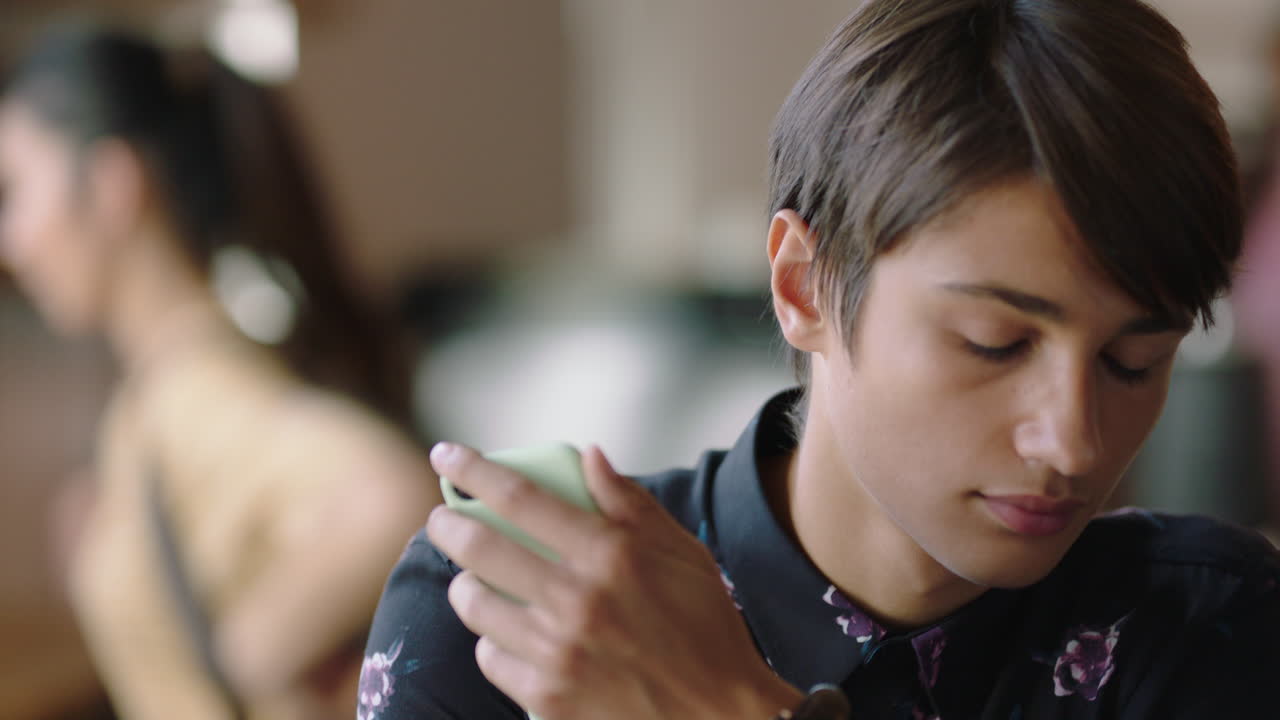 retrato joven hombre caucásico estudiante usando teléfono inteligente en un café navegando en línea mensajes de redes sociales disfrutando de beber café compartiendo estilo de vida leyendo teléfono móvil comunicación por sms