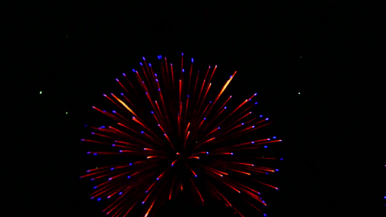 Spettacolari fuochi d'artificio colorati che illuminano il cielo notturno scuro, con scintille radiose, scie luminose e scoppi drammatici che creano un'atmosfera festosa