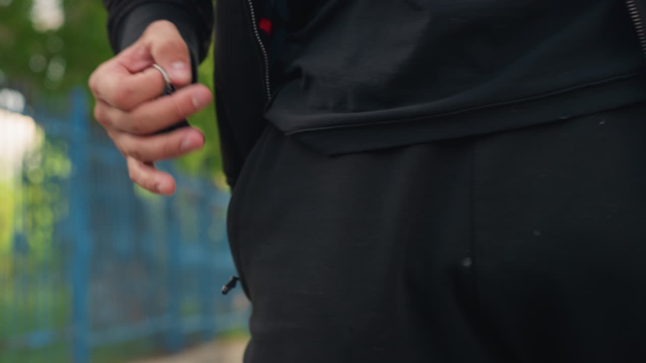 緑豊かな公園の風景のそばで鍵を握る人、活気に満ちた公園環境でポケットの近くに鍵を持つ人、緑豊かな屋外エリア内でポケットの隣で鍵を握る人