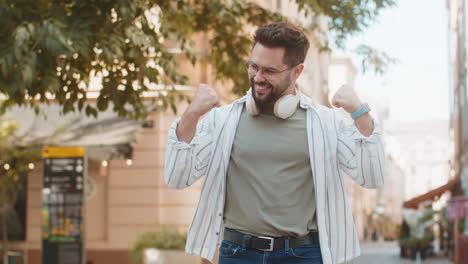 hombre feliz gritando celebrando el éxito ganando el logro de la meta en la calle de la ciudad urbana