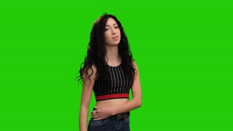 portrait of cute brunette woman with long curly hair shows thumb up gesture on green screen