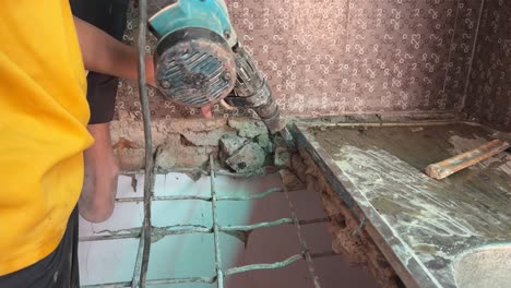 desencadenando la fuerza: poderoso primer plano de manos masculinas que operan un martillo de demolición para derribar una pared, mostrando la fuerza de la construcción y el trabajo